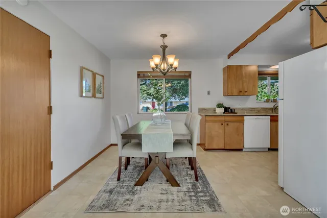a dining room with wooden floor and a chandelier