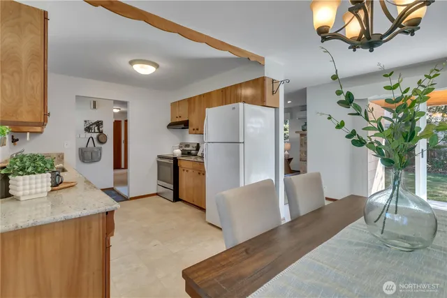 a kitchen with stainless steel appliances a refrigerator a counter space and a view of living room