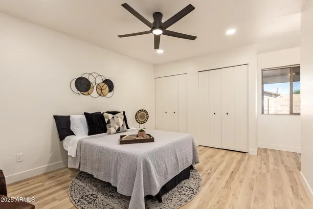 a bedroom with a bed and a table with wooden floor