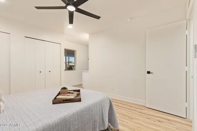 a bedroom with a bed and a ceiling fan
