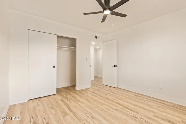 a view of empty room with wooden floor