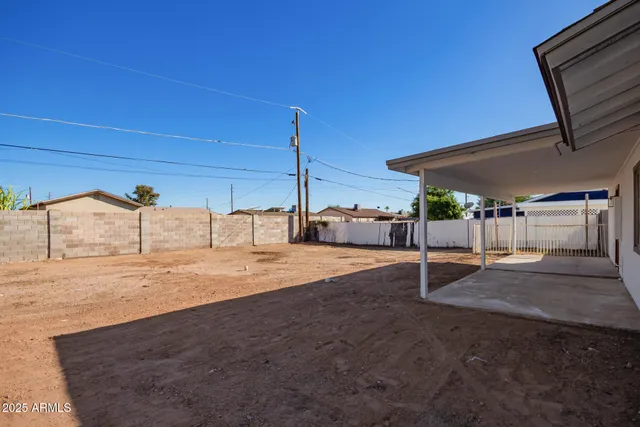 a backyard of a house with table and chairs