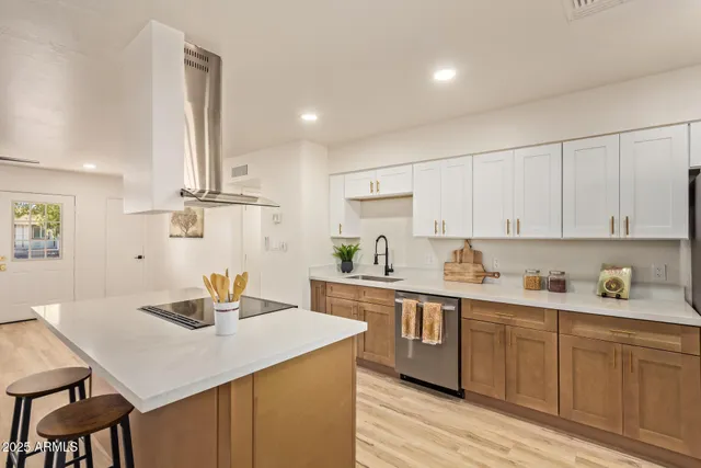 a kitchen with a sink a cabinets and wooden floor