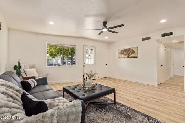 a living room with furniture and a wooden floor