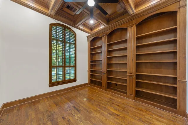 a view of a livingroom with a chandelier wooden floor and windows