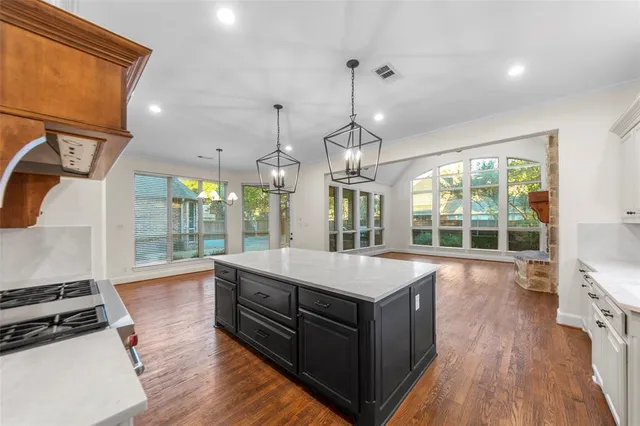 a large kitchen with kitchen island a large island in it
