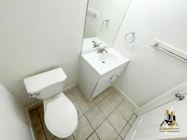a view of a backyard with large trees and wooden fence