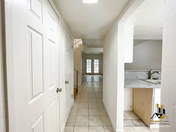 a view of a hallway with wooden floor and a living room