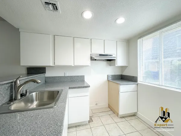 a kitchen with a sink stove and cabinets