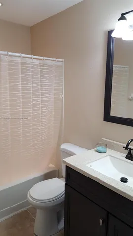 en empty room with windows and chandelier fan