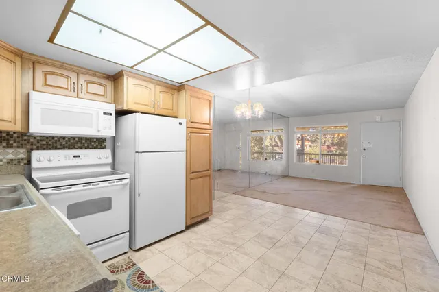a view of kitchen with furniture and refrigerator