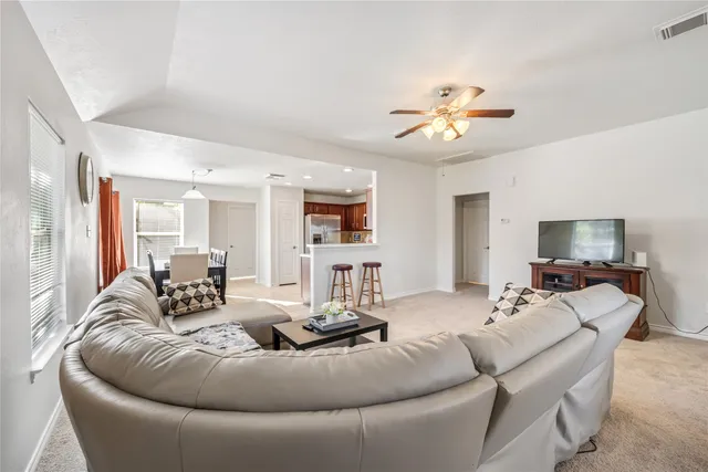 a living room with furniture chandelier and a flat screen tv