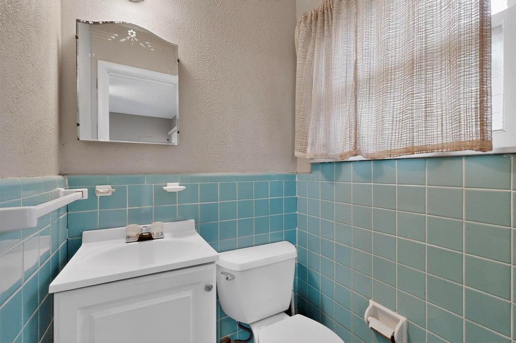 4508 Rutland Avenue Fort Worth, TX 76133 - Photo 17 of 36 a bathroom with a toilet sink and mirror
