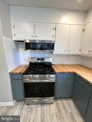 a stove top oven sitting inside of a kitchen