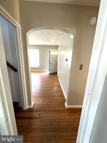 a view of a hallway with wooden floor and staircase