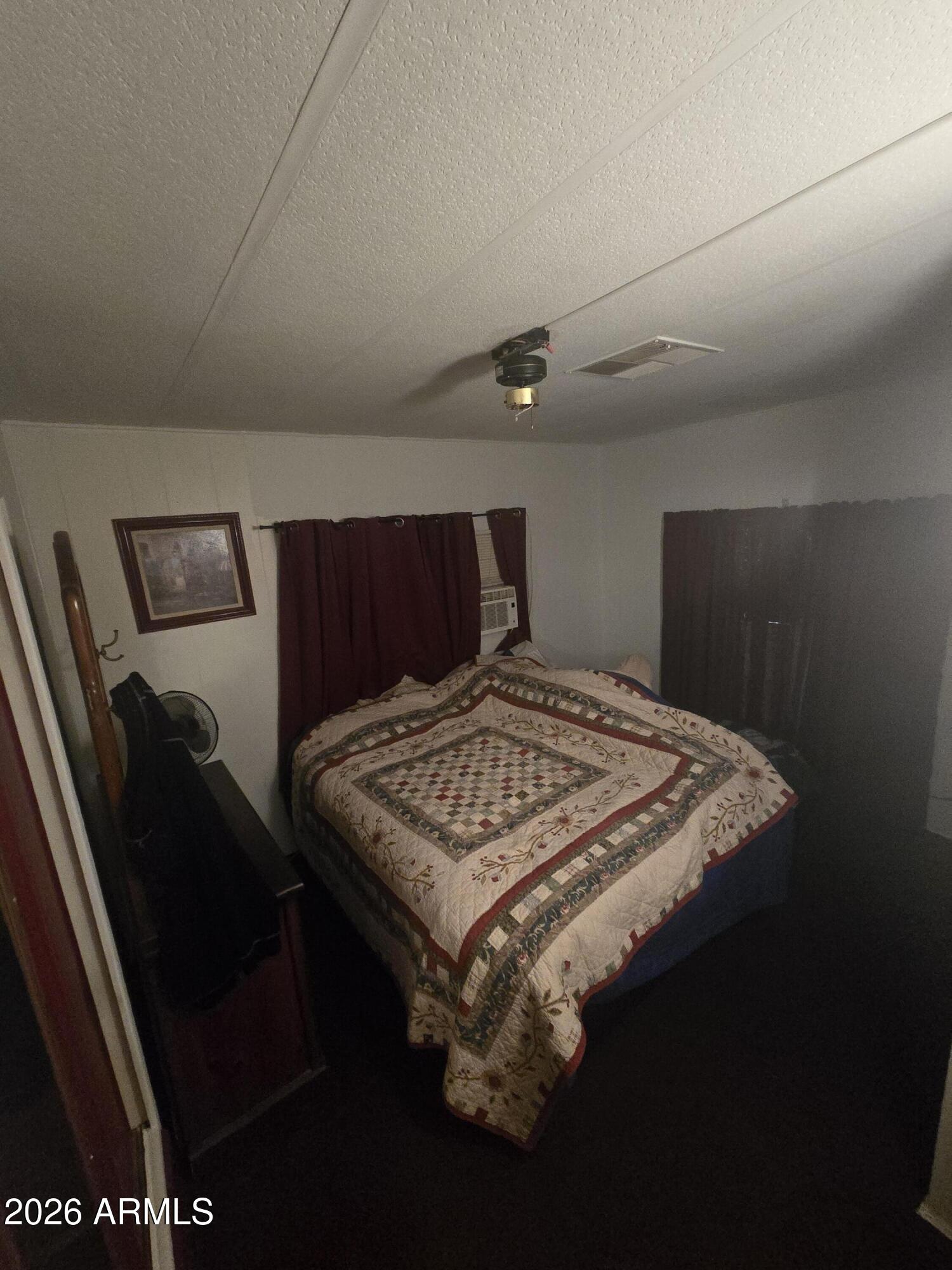 269 North Winchester Road, Unit 26 Apache Junction, AZ 85119 - Photo 11 of 18 a bed sitting in a bedroom next to a window