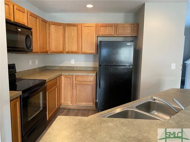 a kitchen with a refrigerator sink and cabinets