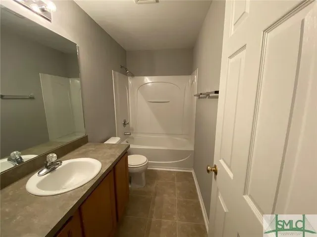 a bathroom with a granite countertop sink toilet a mirror and shower