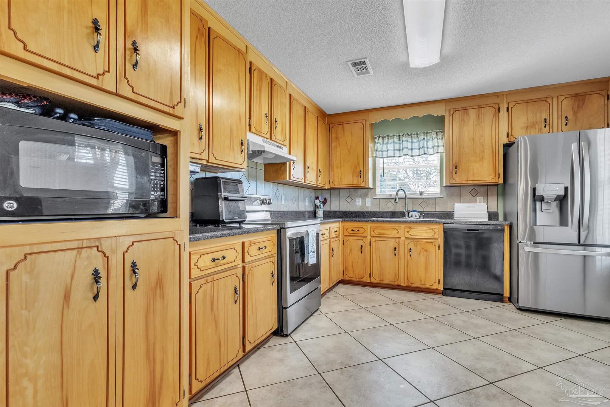 1770 Annie Penton Road Jay, FL 32565 - Photo 17 of 35 a kitchen with a refrigerator sink and cabinets