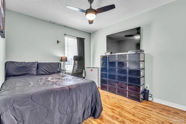 a spacious bedroom with a bed and a flat screen tv