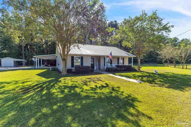 a view of a house with swimming pool and a yard