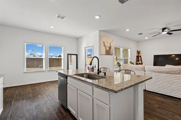 a kitchen with granite countertop a sink and a stove top oven