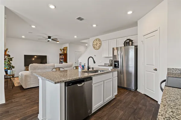 a kitchen with stainless steel appliances granite countertop a sink and refrigerator