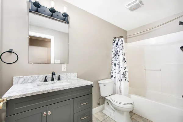 a bathroom with a sink a toilet a mirror a vanity and shower