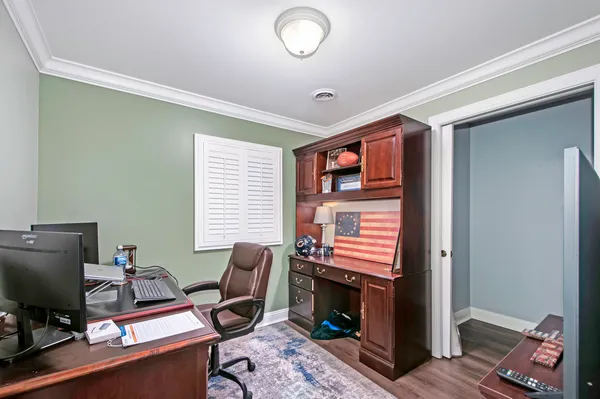 a view of a workspace with furniture and a window