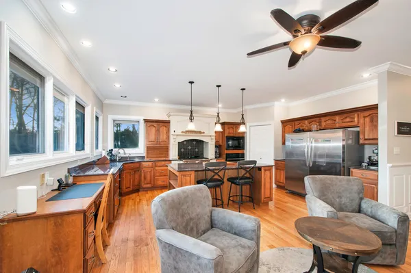 a living room with furniture kitchen view and a large window
