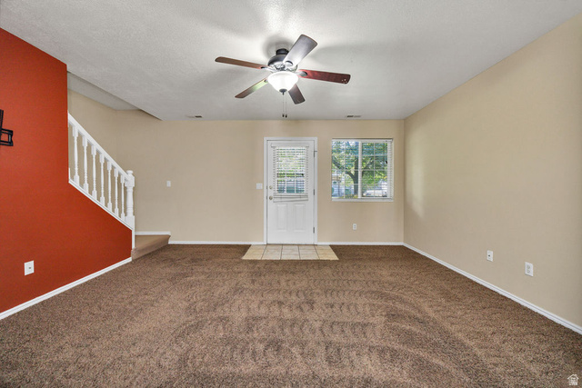 2 West 1780 North Logan, UT 84341 - Photo 9 of 24 Unfurnished living room with ceiling fan, carpet, and a textured ceiling