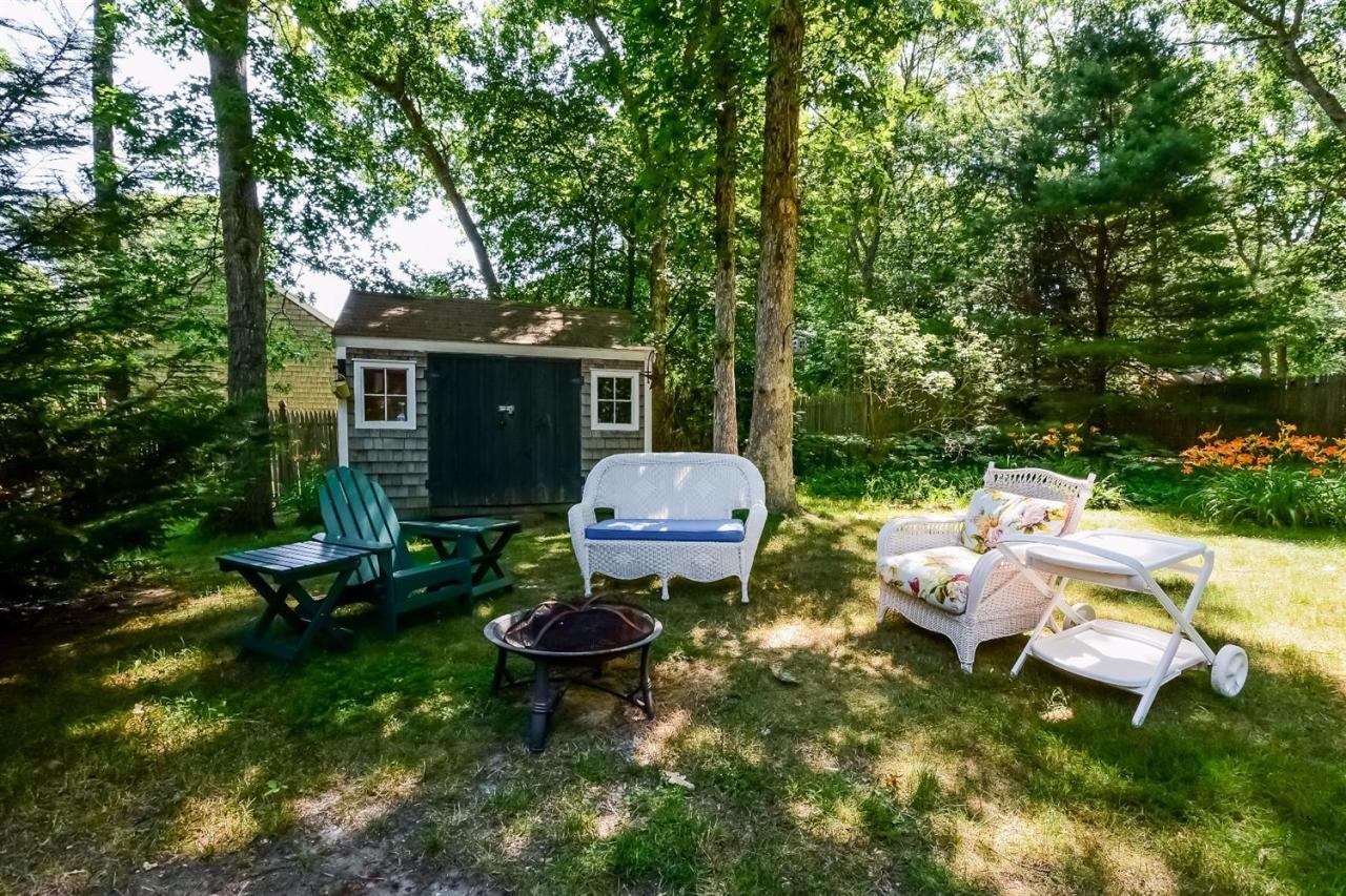 71 Wakeby Road Marstons Mills, MA 02648 - Photo 21 of 31 a backyard of a house with yard fountain and outdoor seating