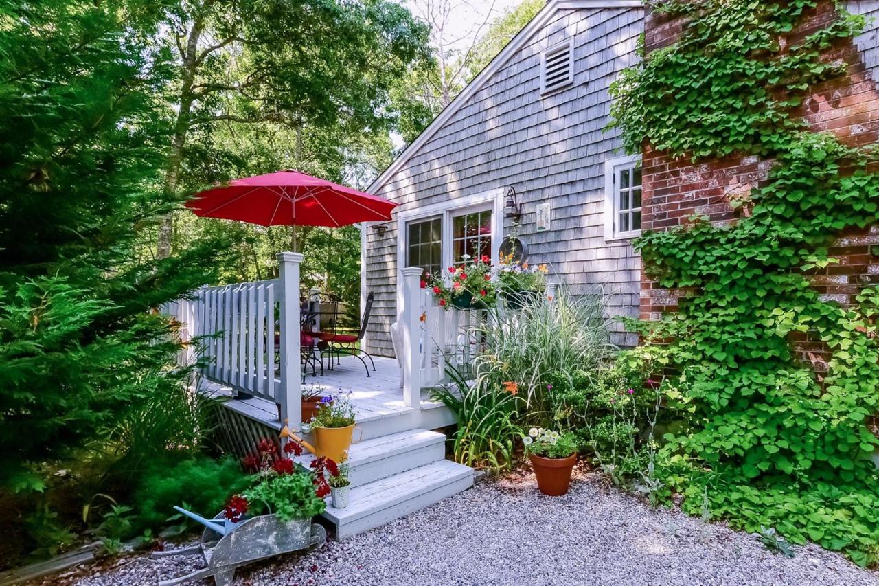 71 Wakeby Road Marstons Mills, MA 02648 - Photo 5 of 31 a view of a backyard with a table and chair under an umbrella