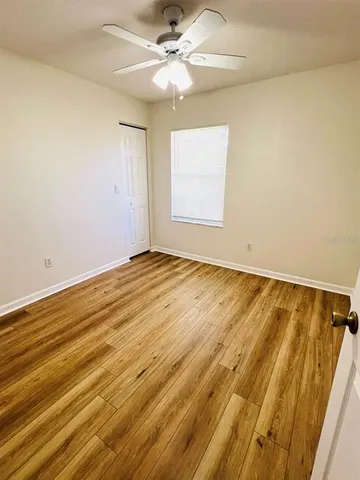 a view of room with wooden floor and fan