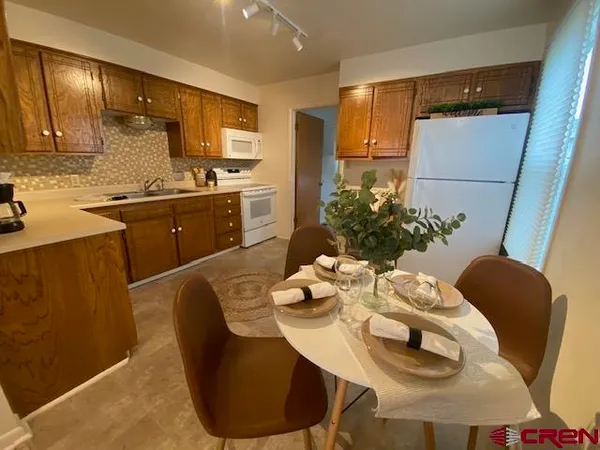 a kitchen with stainless steel appliances granite countertop a dining table chairs and granite counter tops