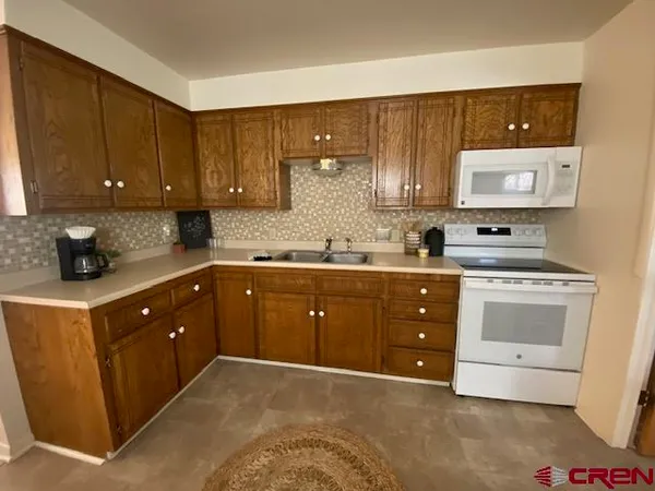 a kitchen with a sink a stove and cabinets