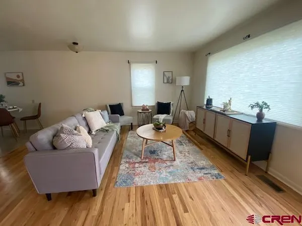 a living room with furniture and wooden floor
