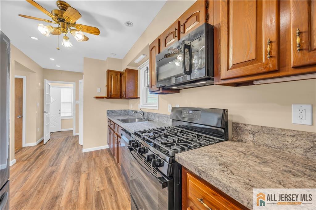 27 Charles Street Carteret, NJ 07008 - Photo 16 of 40 a kitchen with stainless steel appliances granite countertop a stove and a sink
