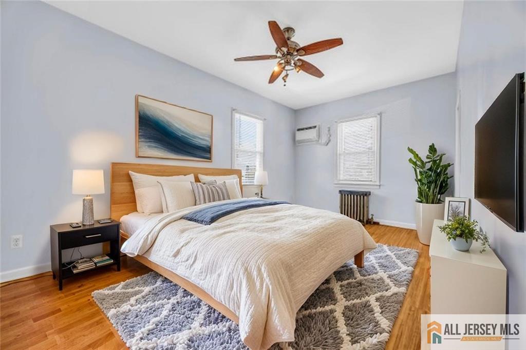 27 Charles Street Carteret, NJ 07008 - Photo 22 of 40 a spacious bedroom with a bed a mirror on dresser and a flat screen tv
