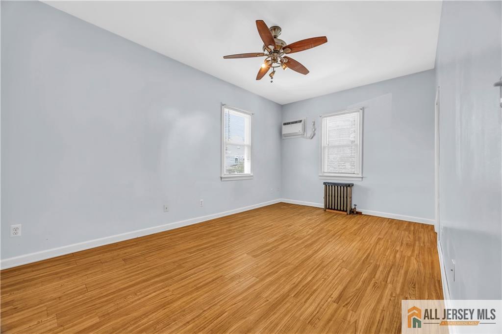 27 Charles Street Carteret, NJ 07008 - Photo 23 of 40 a view of empty room with wooden floor and fan