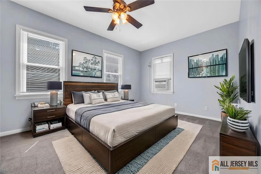 27 Charles Street Carteret, NJ 07008 - Photo 25 of 40 a bedroom with a large bed and a chandelier
