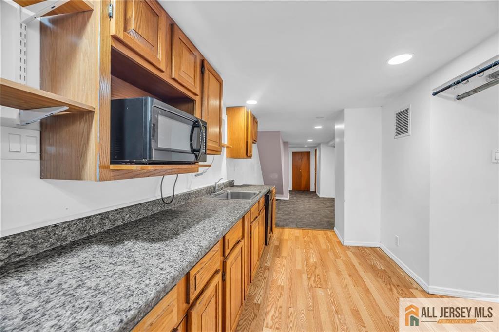 27 Charles Street Carteret, NJ 07008 - Photo 34 of 40 a bathroom with a granite countertop sink and mirror
