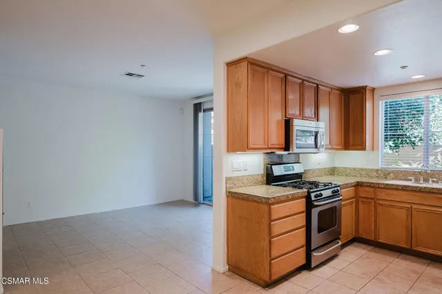 a kitchen with stainless steel appliances granite countertop a stove a sink and a refrigerator