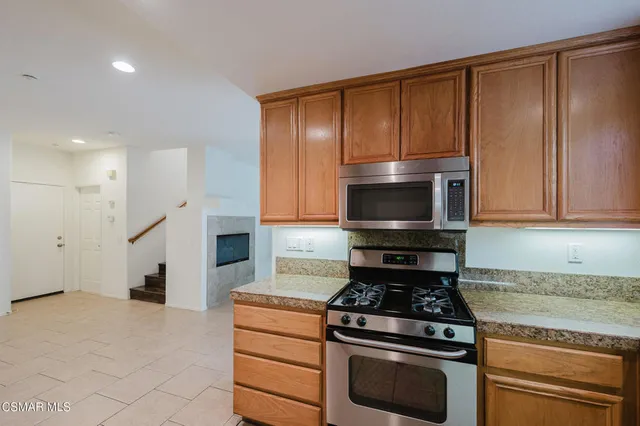 a kitchen with granite countertop wooden cabinets and stainless steel appliances