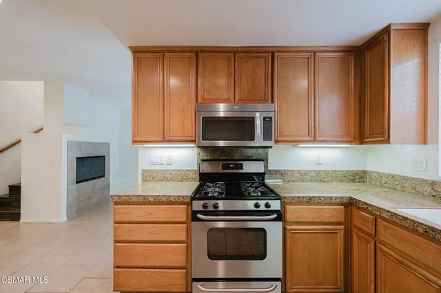 a kitchen with granite countertop stainless steel appliances a stove a microwave and cabinets