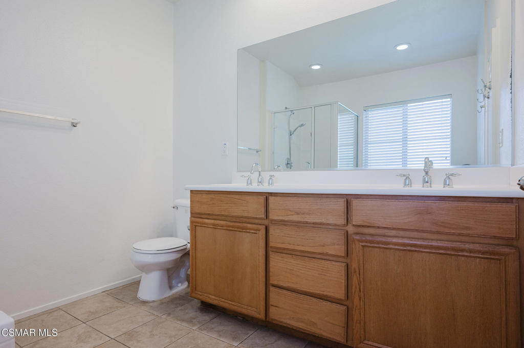 1454 Patricia Avenue, Unit 402 Simi Valley, CA 93065 - Photo 29 of 50 a bathroom with a sink toilet and mirror