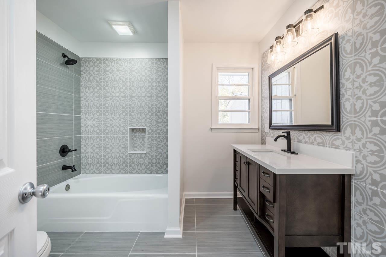 8 Holmes Circle Durham, NC 27713 - Photo 11 of 20 a bathroom with a tub sink and mirror