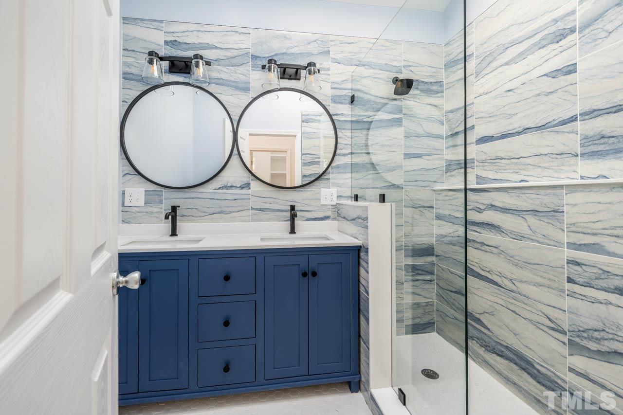 8 Holmes Circle Durham, NC 27713 - Photo 15 of 20 a bathroom with a sink mirror vanity and shower