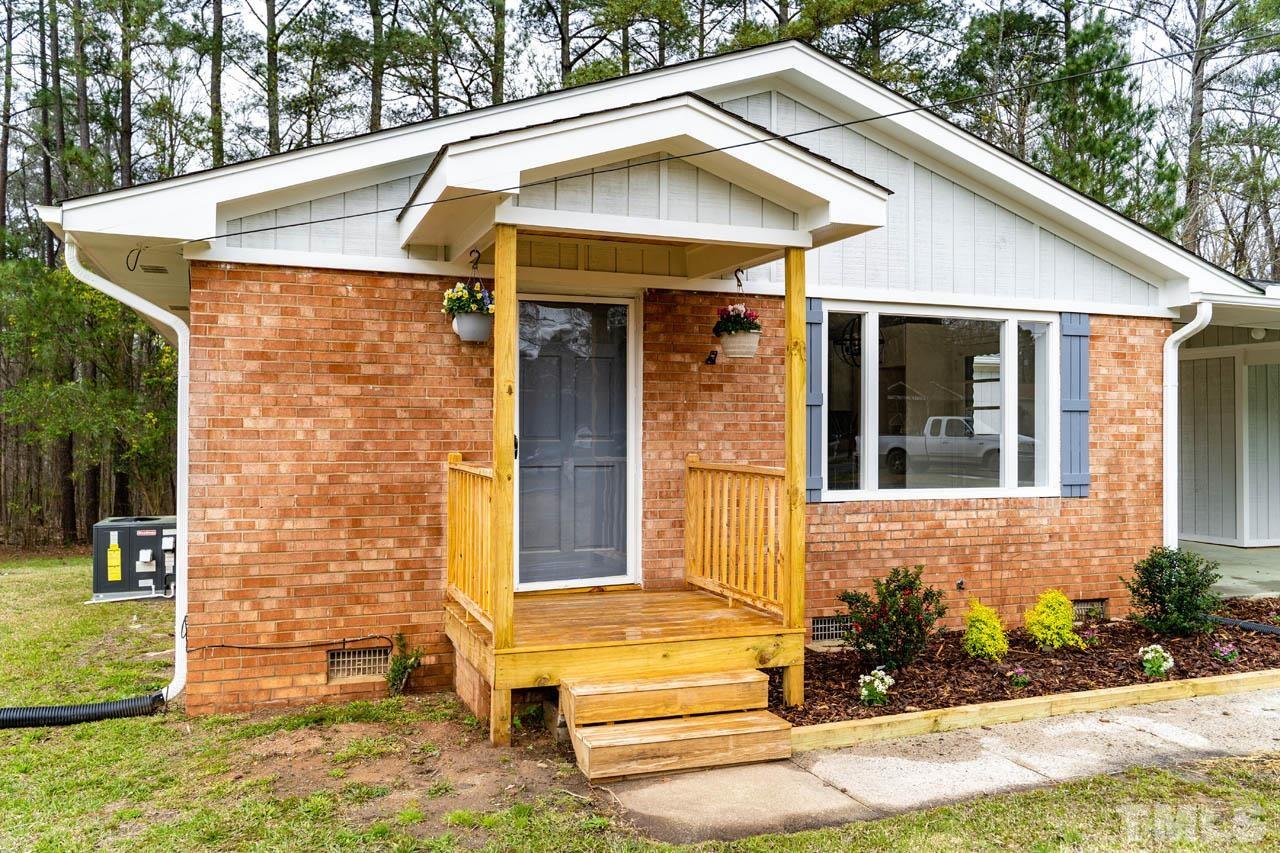 8 Holmes Circle Durham, NC 27713 - Photo 20 of 20 a view of a white house with large windows and flower plants