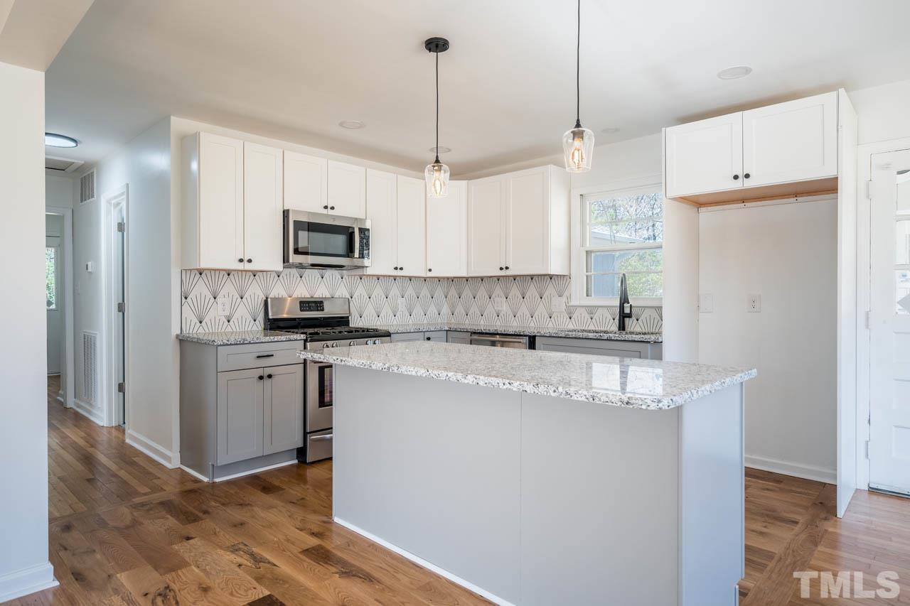 8 Holmes Circle Durham, NC 27713 - Photo 5 of 20 a kitchen with stainless steel appliances granite countertop a refrigerator a sink a stove a microwave and white cabinets